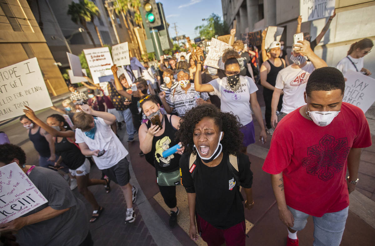 A crowd of at least 300 protesters march in downtown Las Vegas on Wednesday, June 3, 2020, as p ...