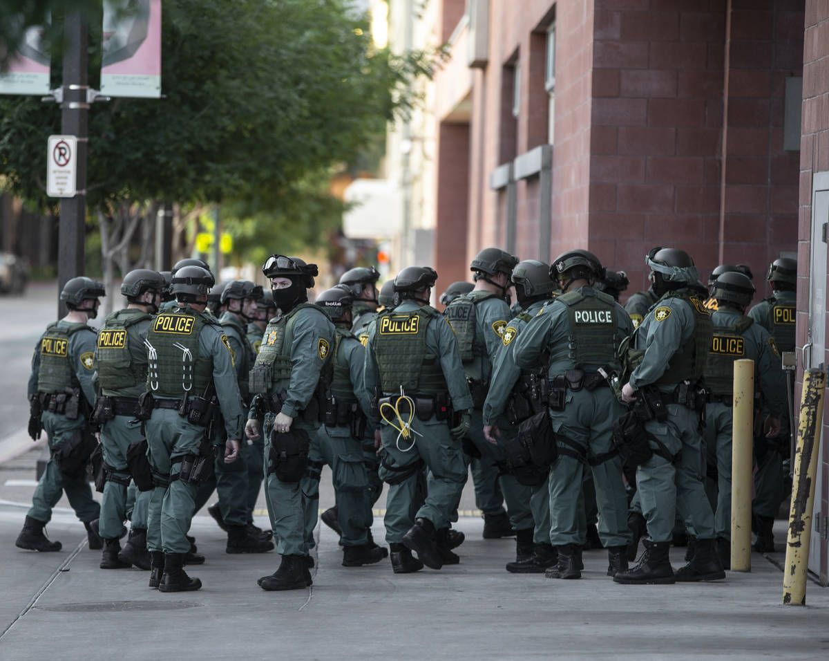 Police officers mobilize in downtown Las Vegas on Wednesday, June 3, 2020, as riots continue th ...