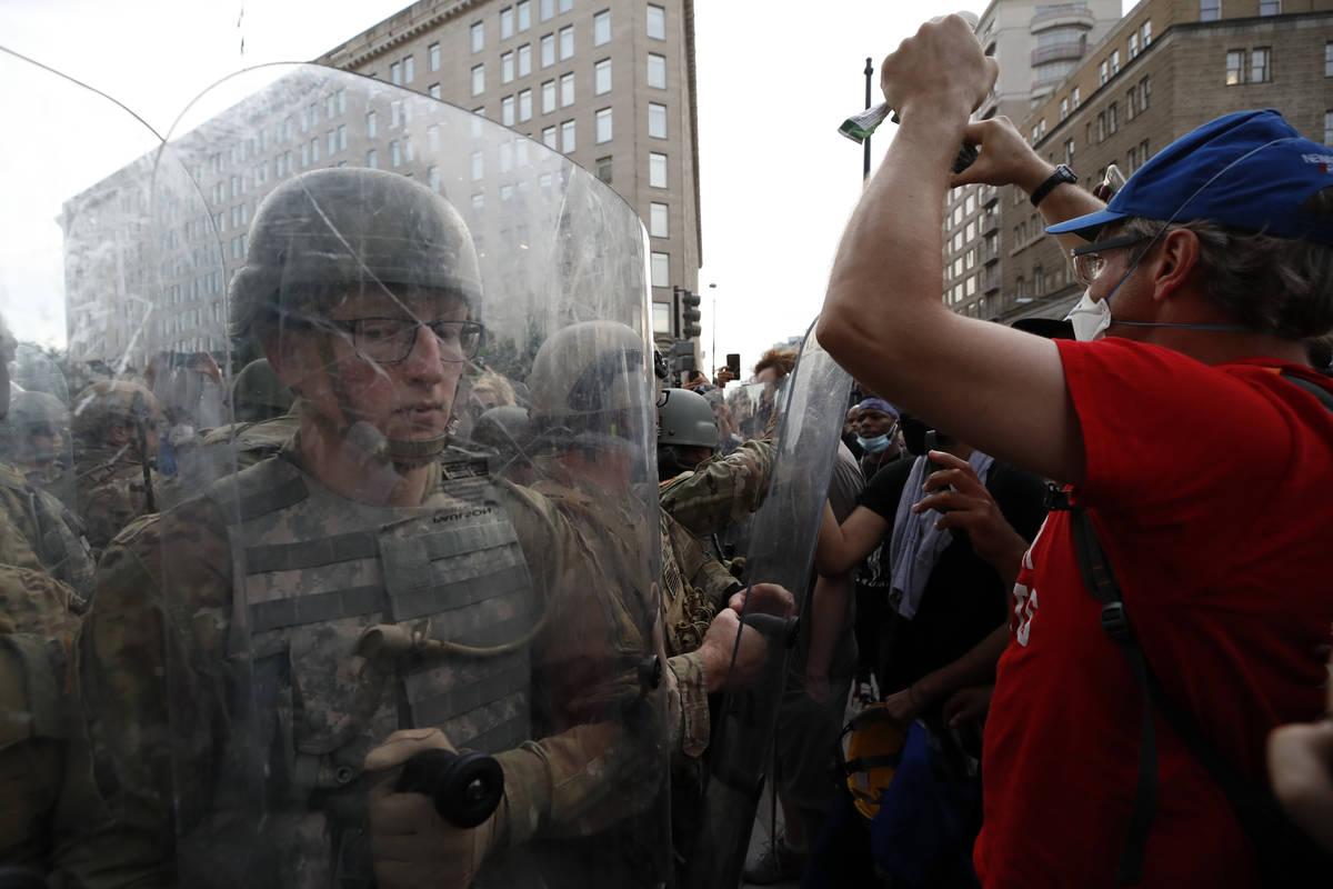 National Guard soldiers walk as they unload from buses as demonstrators gather to protest the d ...