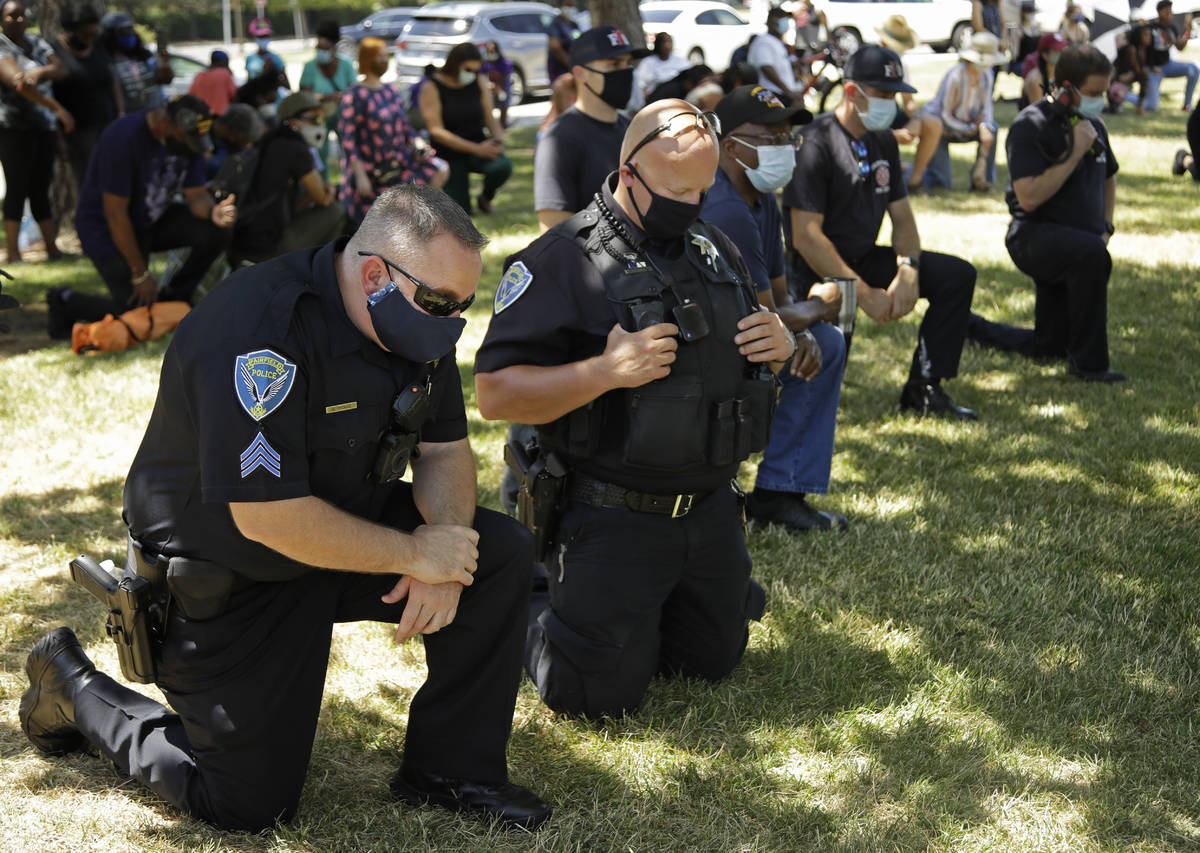 Fairfield police officers kneel during "Taking a knee for Justice and Prayer" service ...