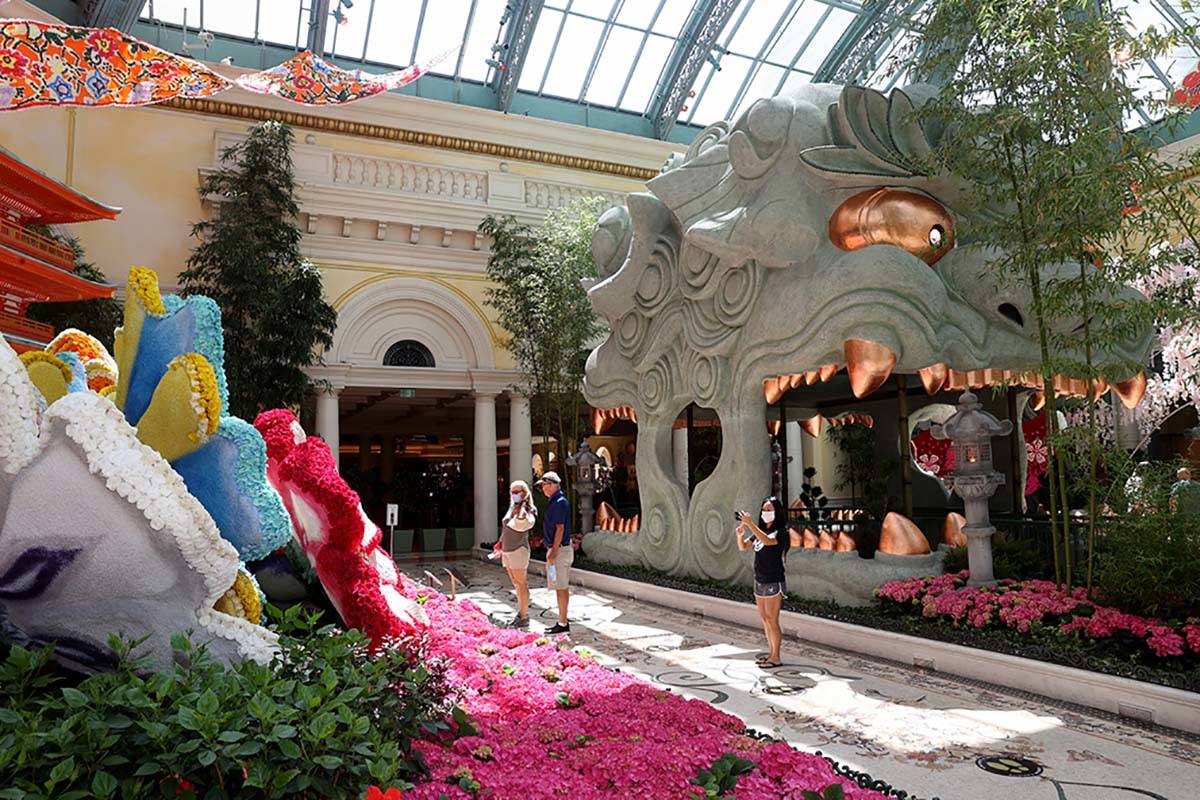 Guests maintain social distance inside the Conservatory at the Bellagio on the Strip in Las Veg ...