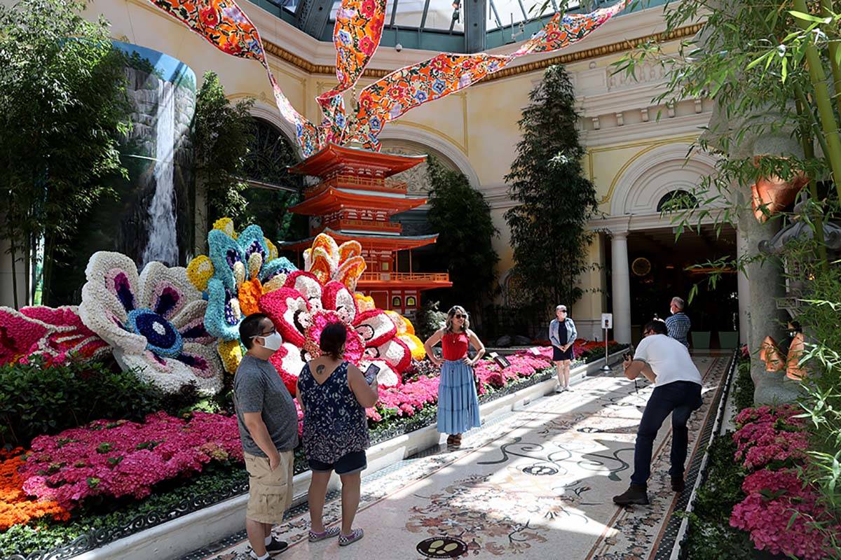 Guests maintain social distance inside the Conservatory at the Bellagio on the Strip in Las Veg ...