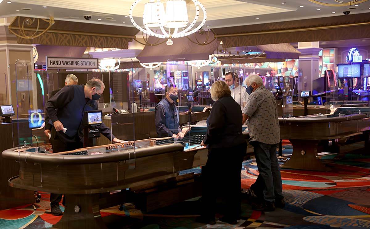 Guests play craps at the Bellagio on the Strip in Las Vegas as the resort reopens after 78 days ...