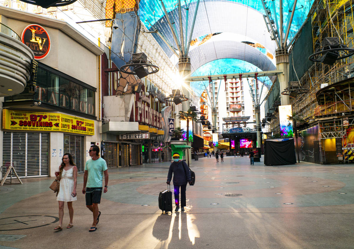 People walk around the Fremont Street Experience as hotel-casinos reopen in downtown Las Vegas ...