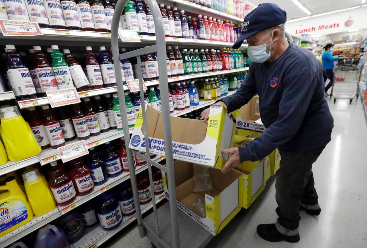 In a Wednesday, June 3, 2020 photo, Juan Santos stocks shelves at the Presidente Supermarket in ...
