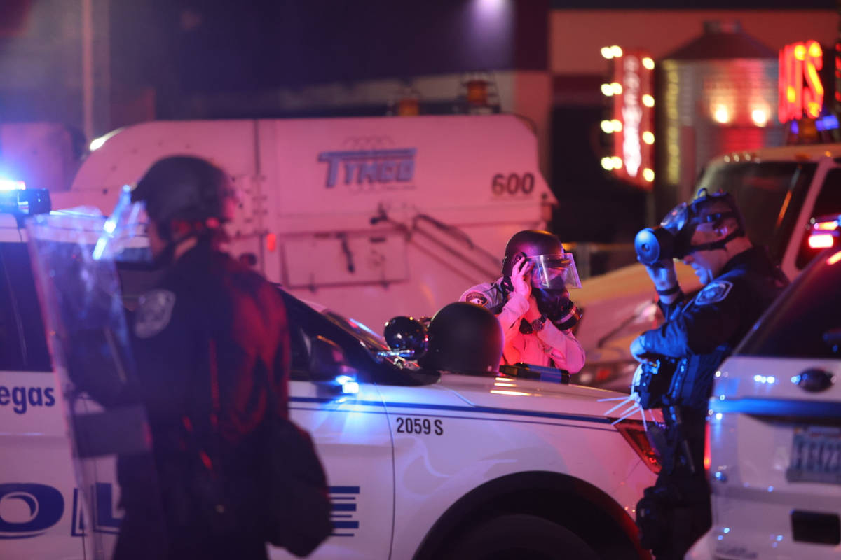 Officers place gas masks on at Fremont Street and Las Vegas Boulevard South prior to deploying ...