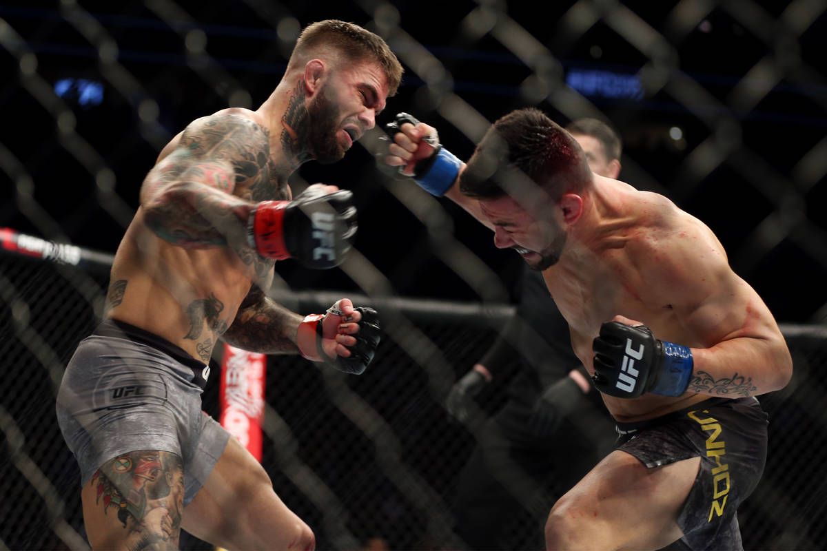 Pedro Munhoz, right, connects a punch to knockout Cody Garbrandt in the first round of the bant ...