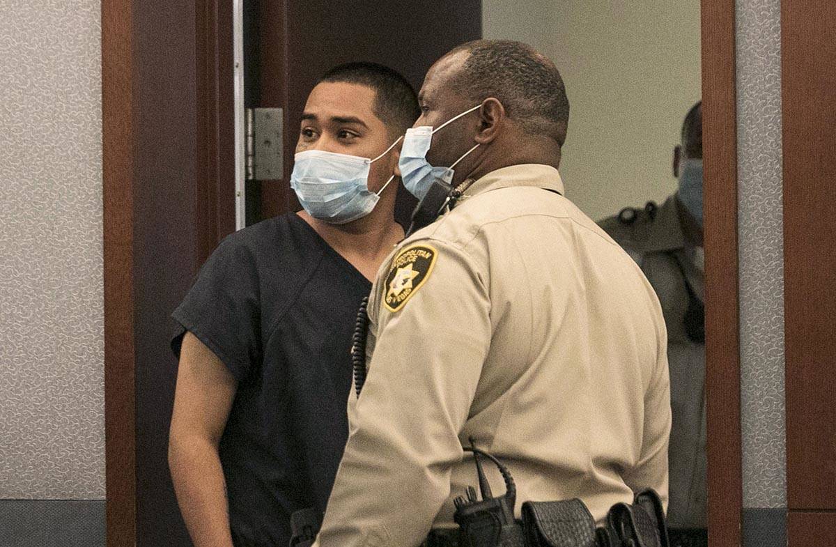 Edgar Samaniego, charged in shooting of Las Vegas police officer, looks behind as he is led out ...