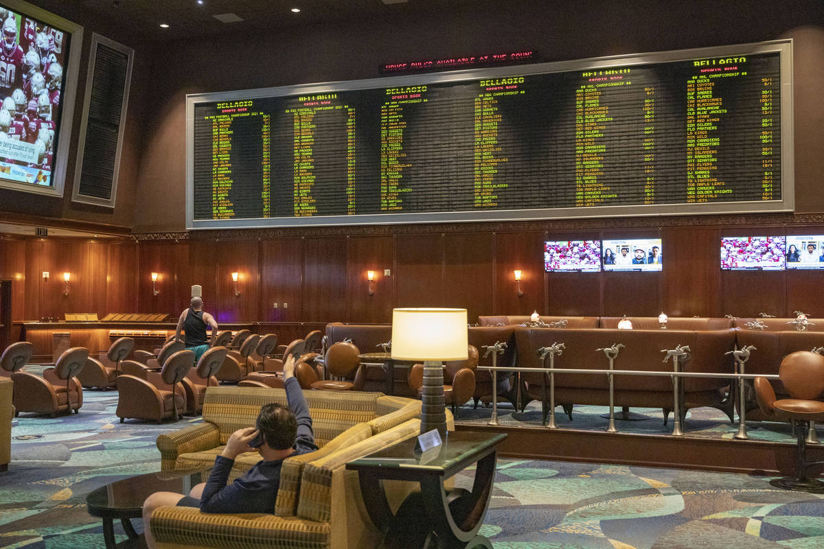 Individuals wait for a horse race to begin during the reopening of the Bellagio sportsbook, Thu ...