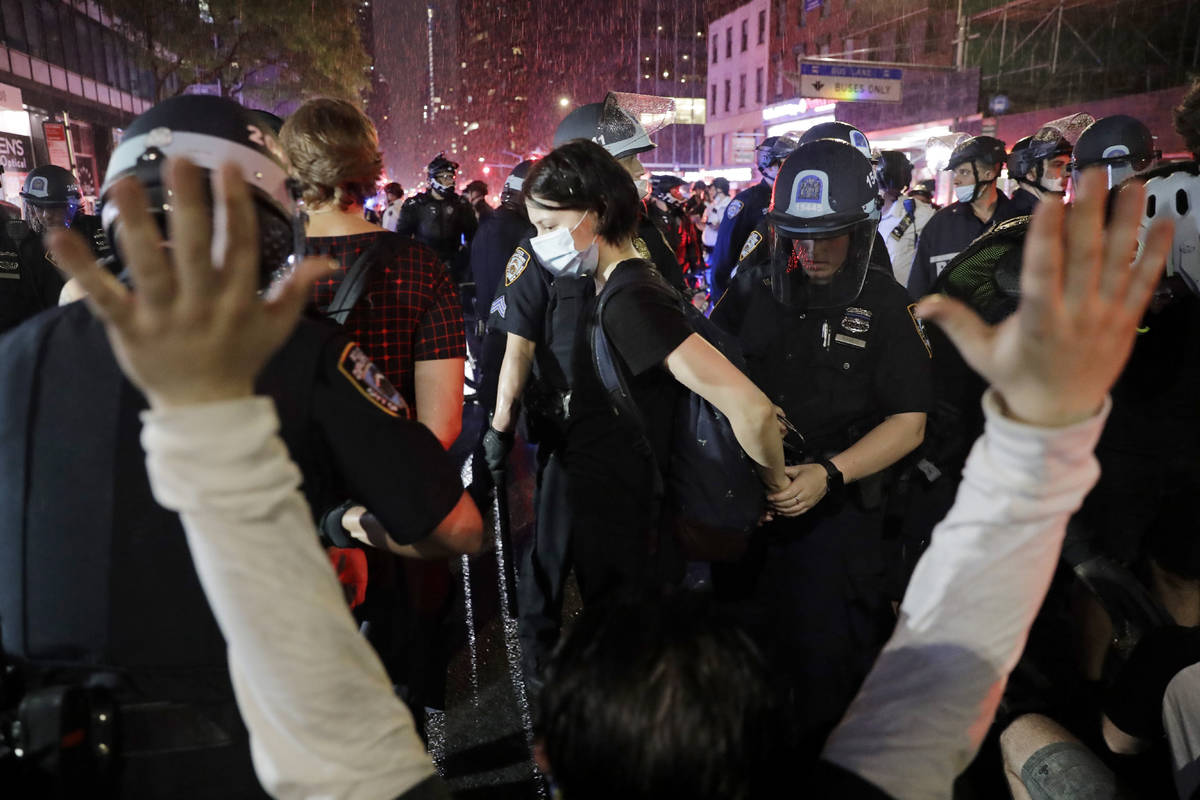 Police arrest protesters as they march through the streets of Manhattan, New York, Wednesday, J ...