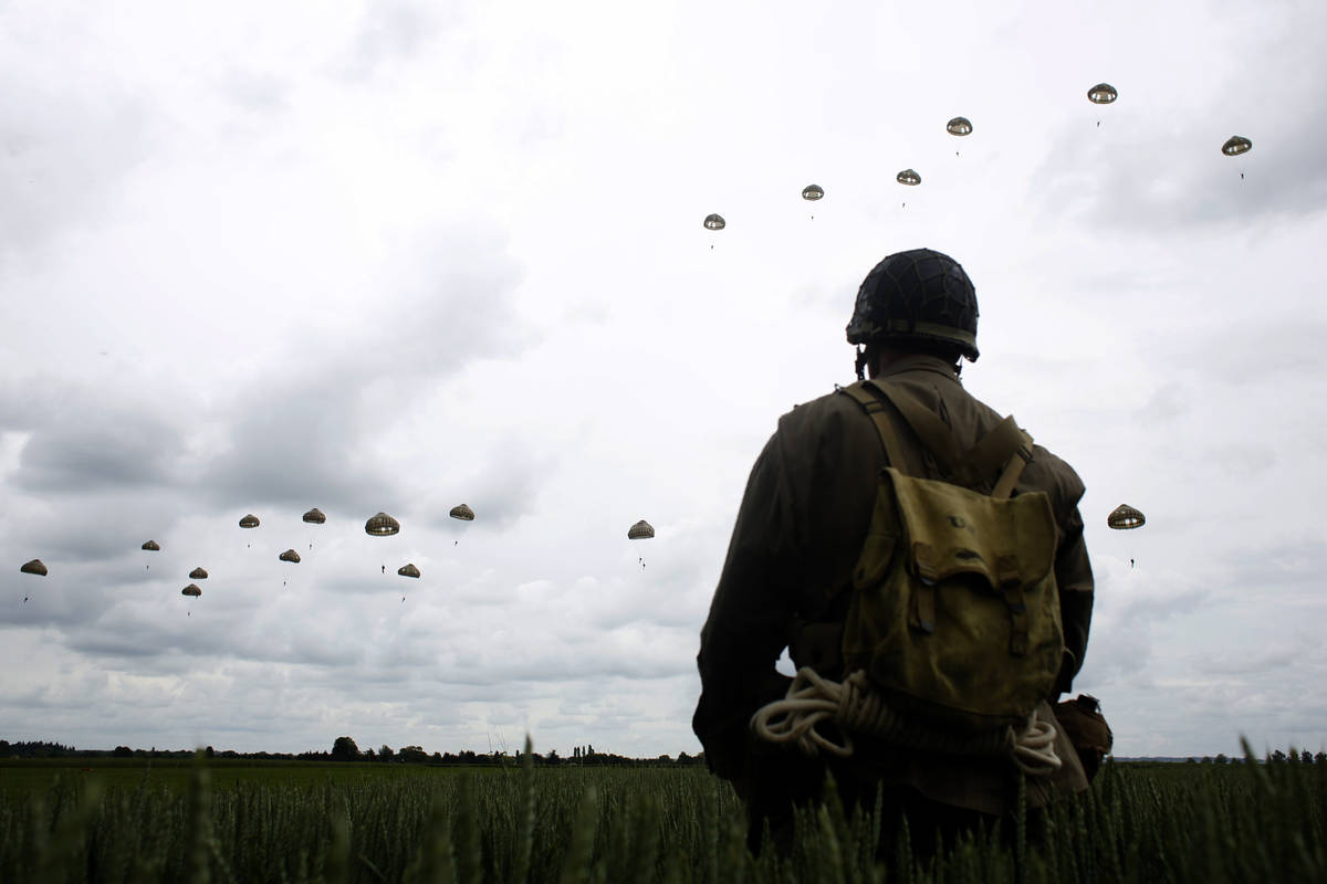 In a Wednesday, June 5, 2019, file photo, a WWII enthusiast watches French and British parachut ...