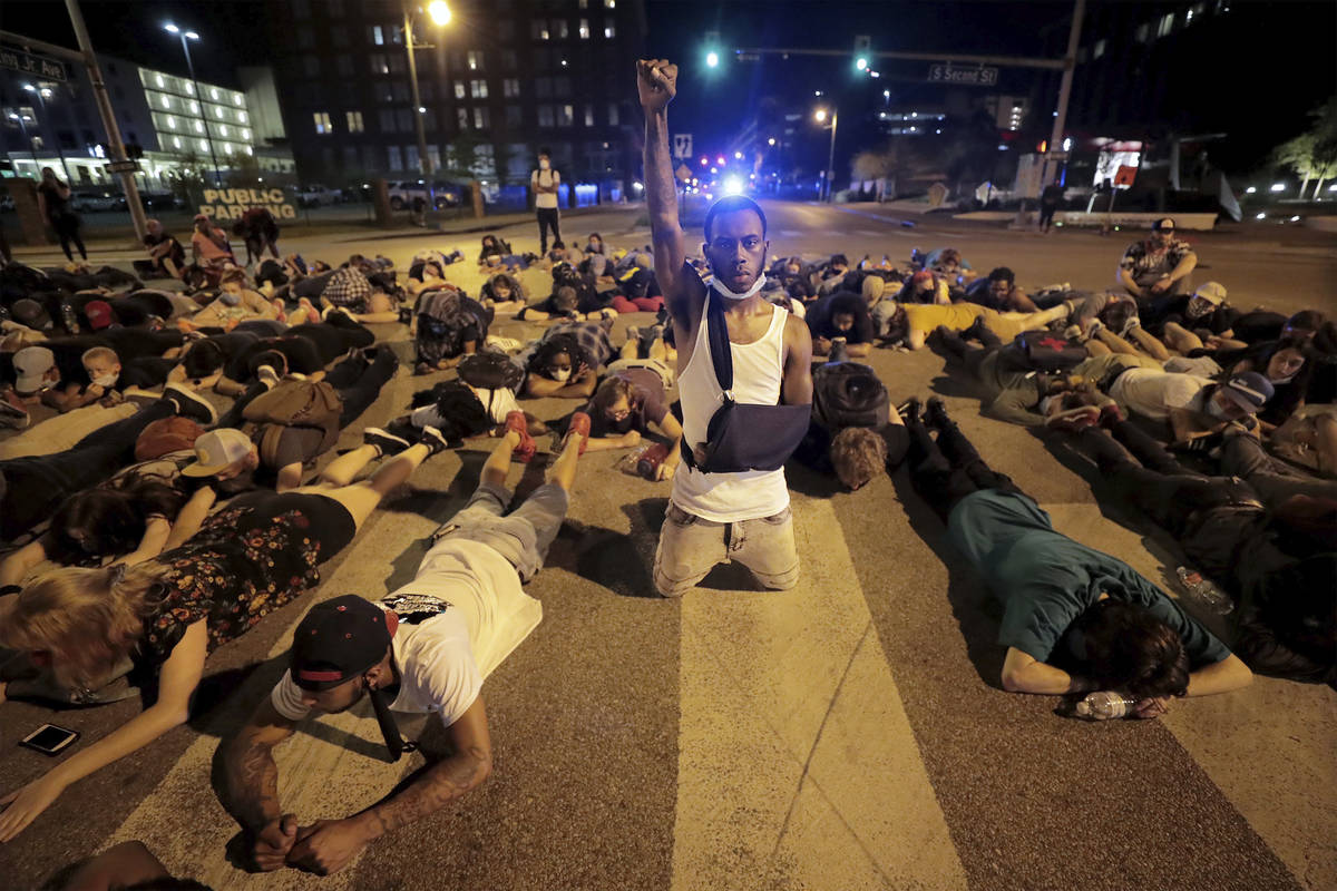 Protesters lay in the middle of the intersection of Dr. Martin Luther King, Jr. Blvd. and Secon ...