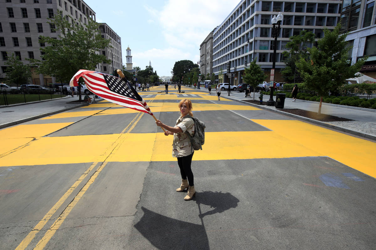 Beth Shafa waves an American Flag near the White House, Friday, June 5, 2020, in Washington. Ci ...