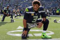 Seattle Seahawks quarterback Russell Wilson stretches before an NFL football game against the T ...