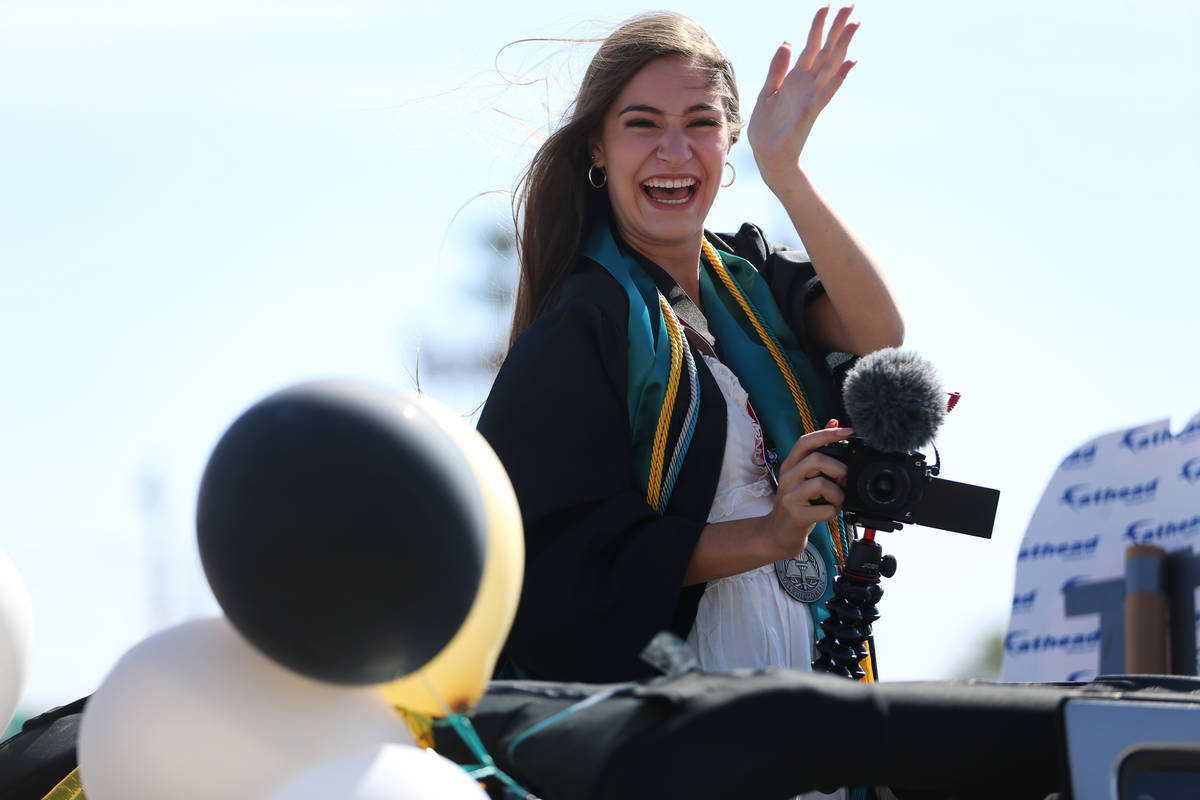 Senior Ellie Grace Kay, 17, waves as she gets ready for the Las Vegas Academy drive-through gra ...