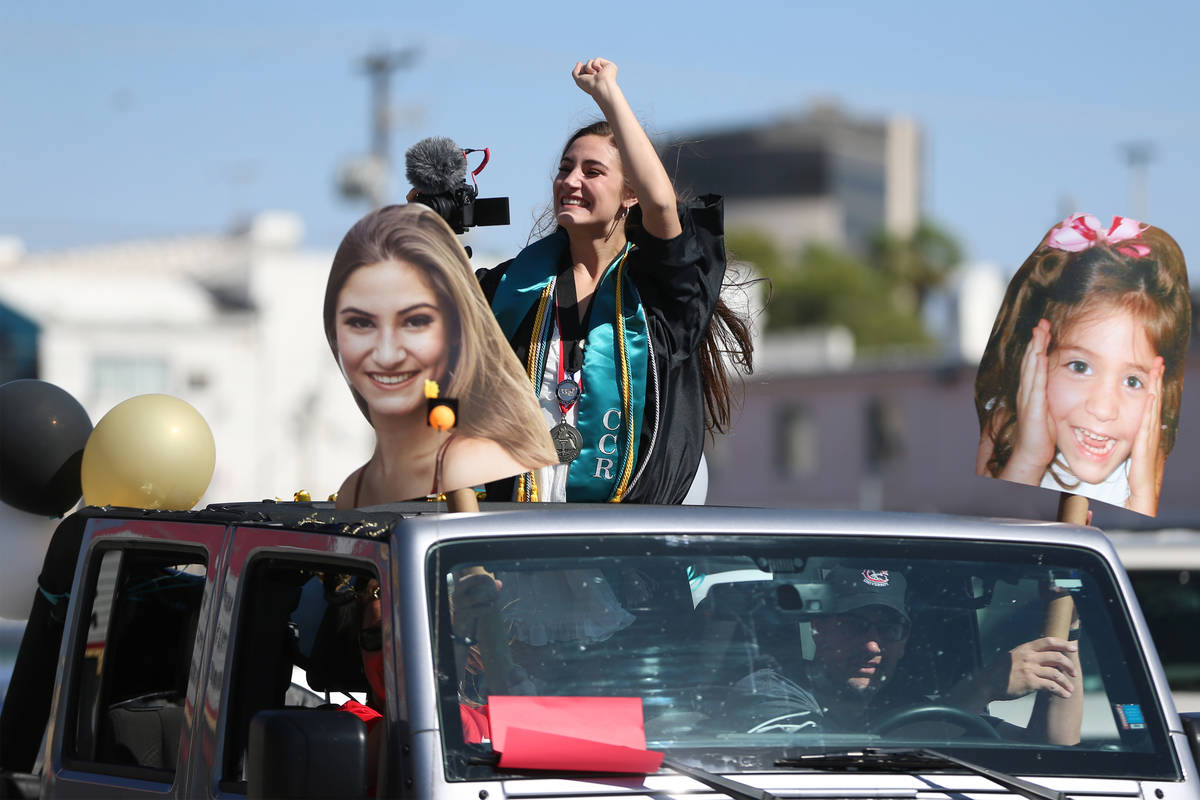 Senior Ellie Grace Kay, 17, waves as she gets ready for the Las Vegas Academy drive-through gra ...