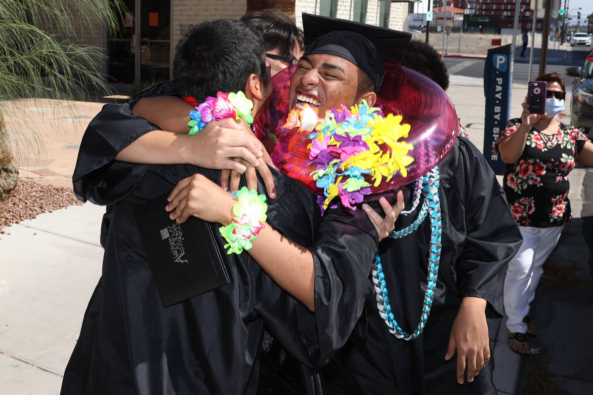 Seniors Sergio Gamboa, 18, from left, Josh Salvador, and Aris Harper, embrace each other after ...