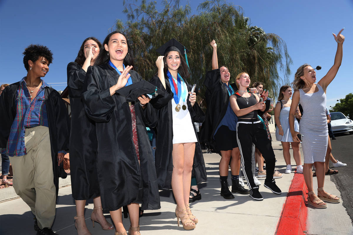 People including seniors cheer on their classmates during the Las Vegas Academy of the Arts dri ...