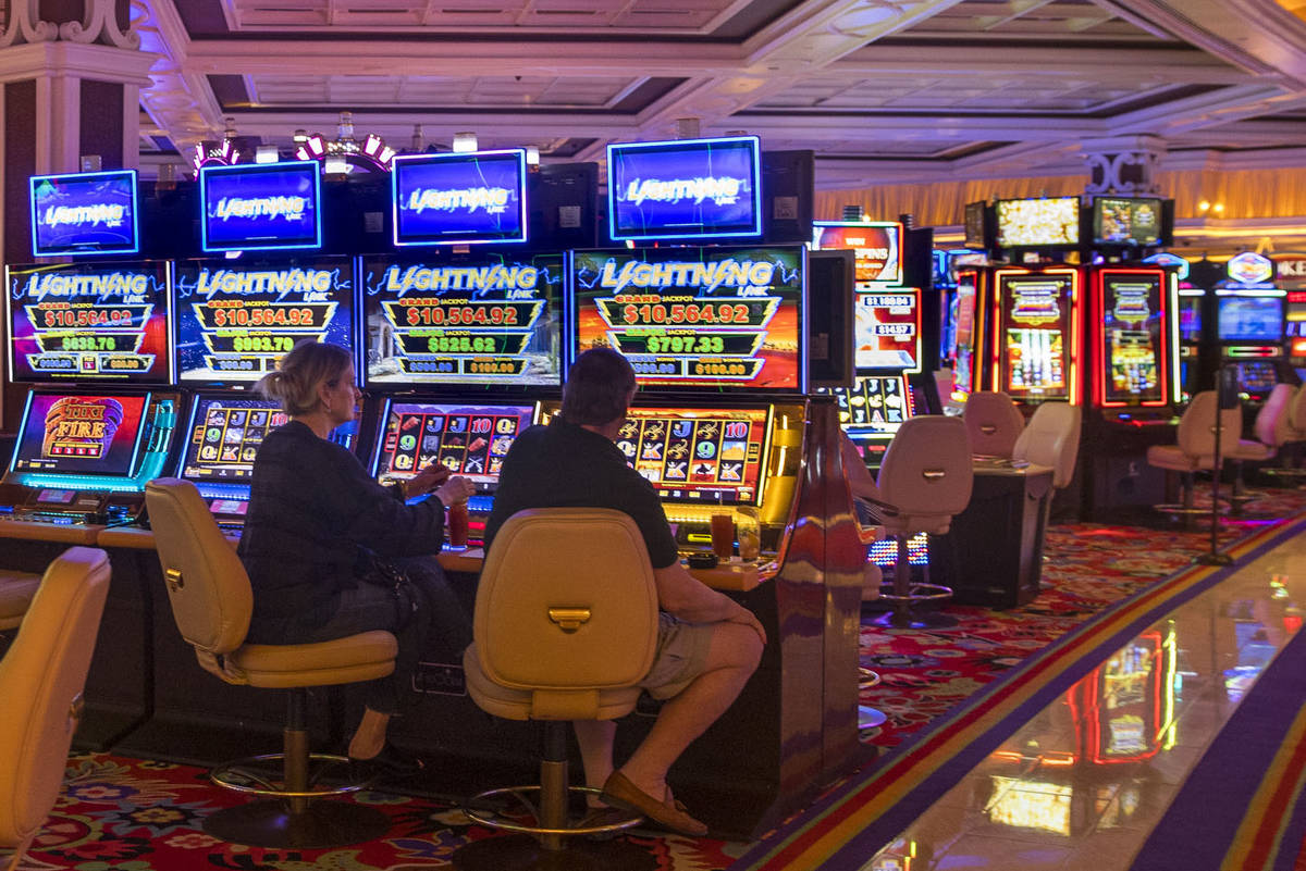 Slot players at the Wynn Las Vegas sit side by side while Gov. Steve Sisolak tours the casino t ...
