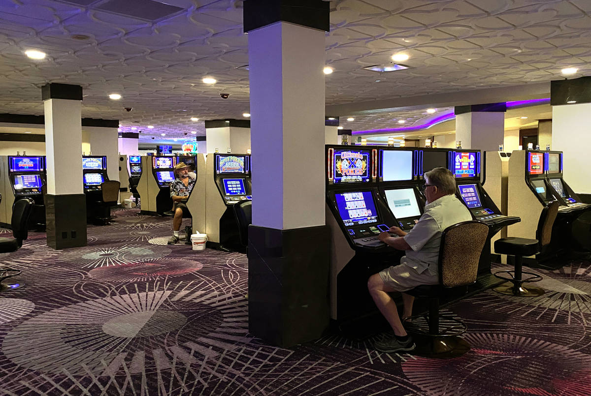 Slot machines and players at Harrah's are staged for social distancing as they are open for bus ...