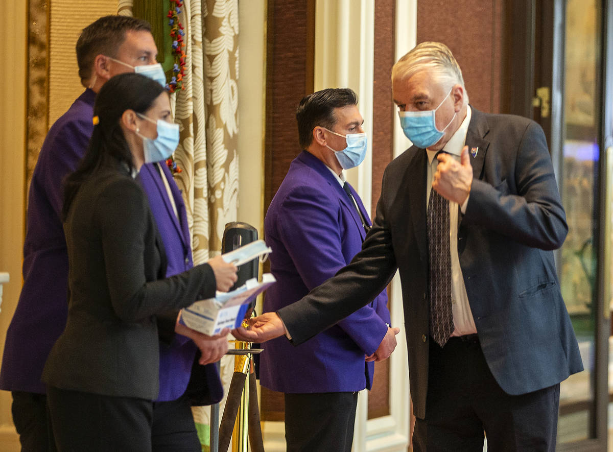 Gov. Steve Sisolak, right, grabs more hand sanitizer during a tour at the Wynn Las Vegas to vie ...