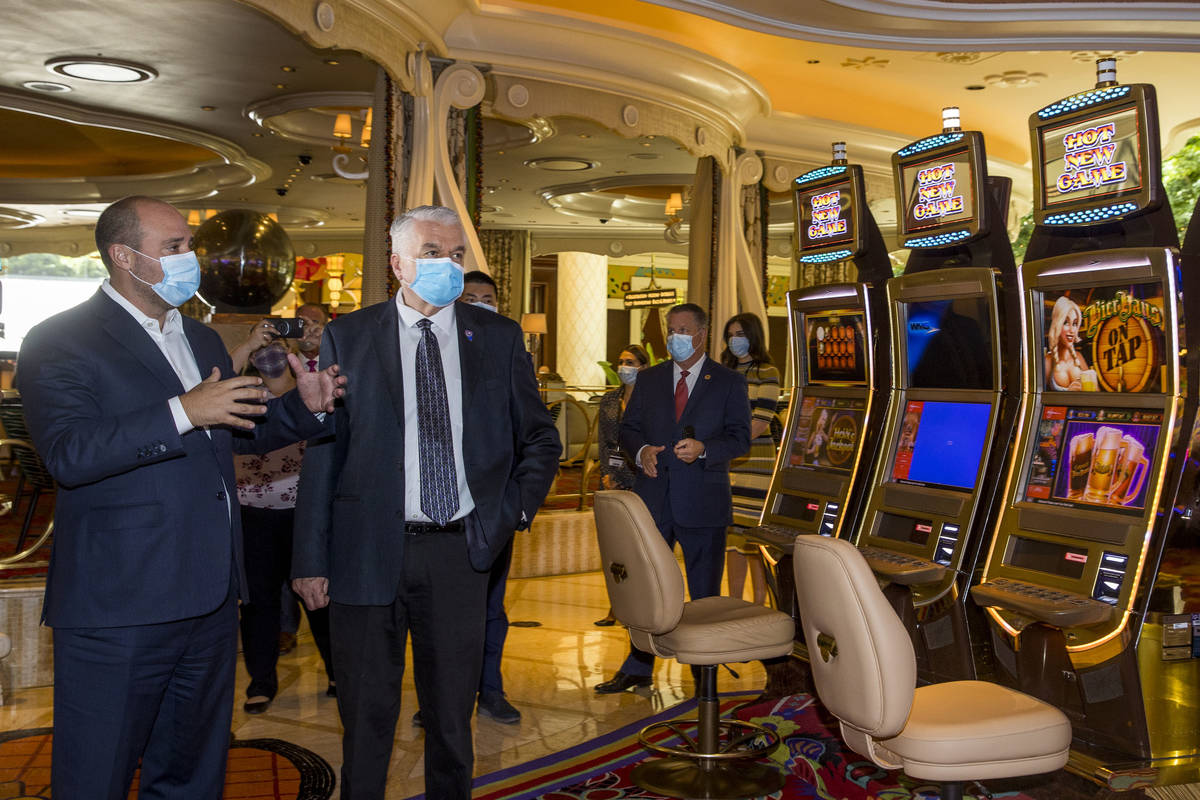 Wynn Las Vegas CEO Matt Maddox talks with Gov. Steve Sisolak during a tour to view their corona ...
