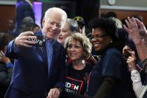 Former Vice President Joe Biden takes photographs with supporters during a caucus night event a ...