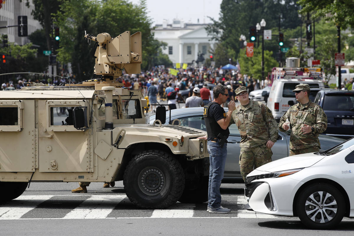 A checkpoint blocks traffic on 16th Street Northwest as people gather near the White House, Sat ...