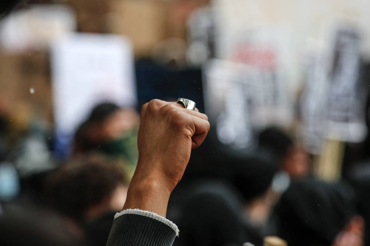 A woman clenches her fist during a Black Lives Matter rally in Parliament Square in London, Sat ...