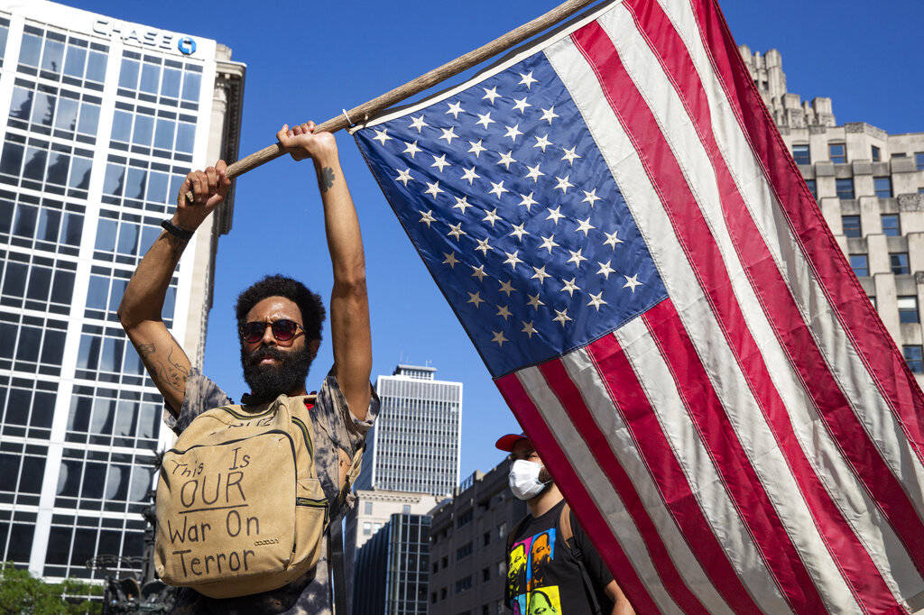 A protester holds a flag at Monument Circle following a non-violent sit-in at the Statehouse in ...