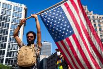 A protester holds a flag at Monument Circle following a non-violent sit-in at the Statehouse in ...