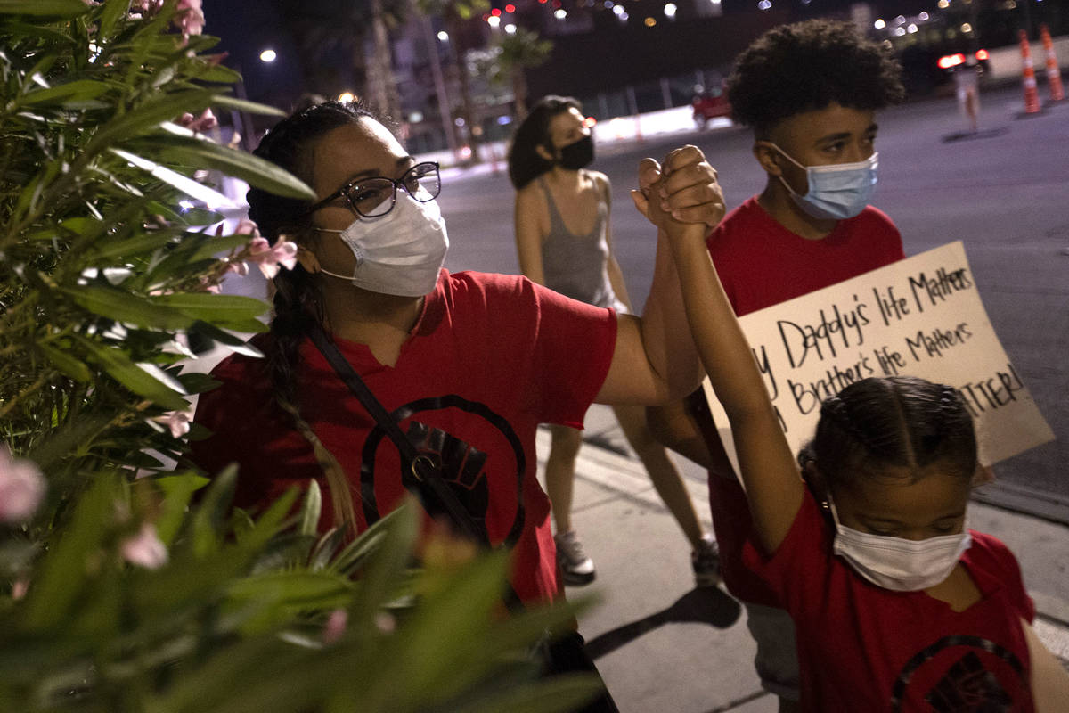 A small group of people march down Las Vegas Boulevard in protest of police brutality and the d ...