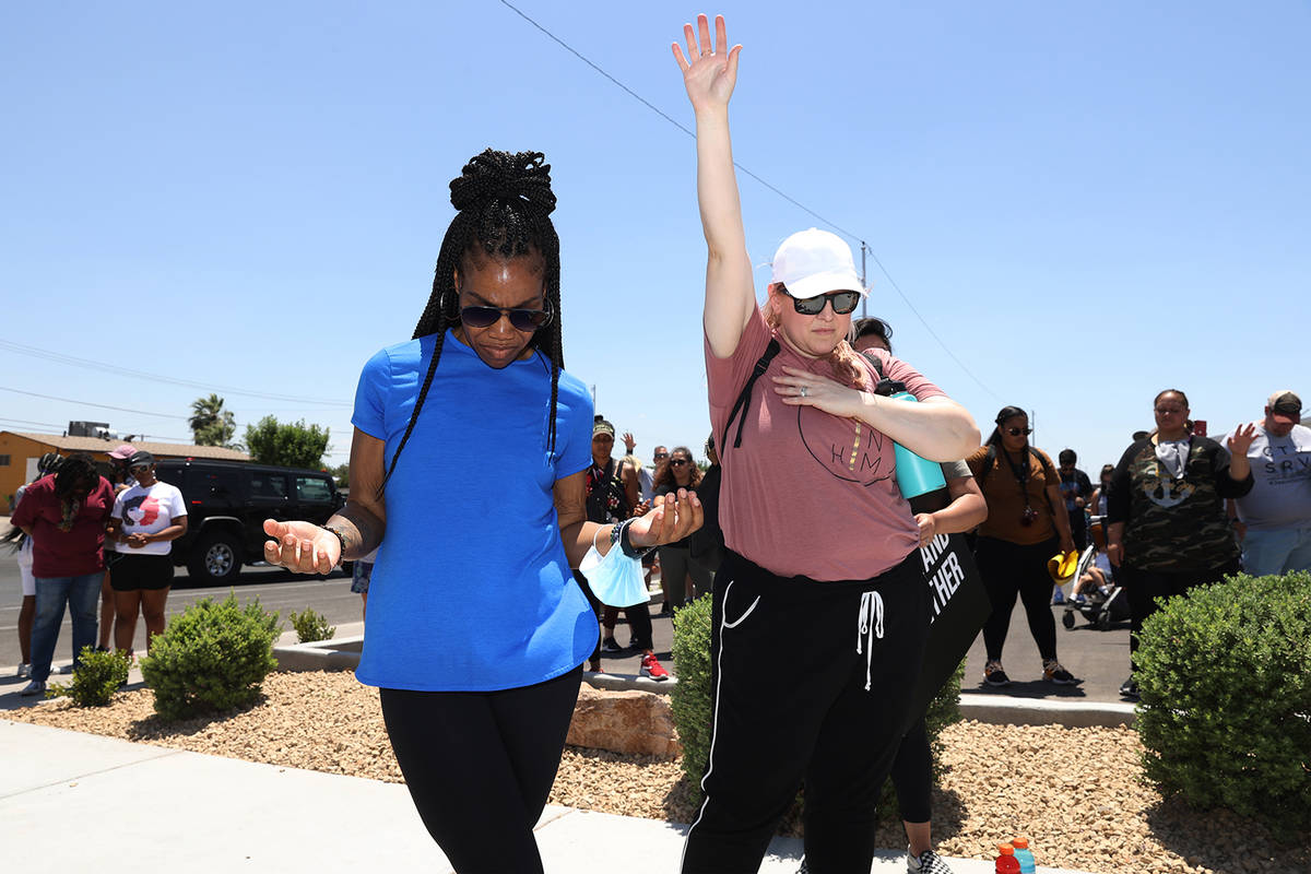 Friends Chantal Perry, left, and Sherry Asuncion, participate in a prayer outside of the True L ...