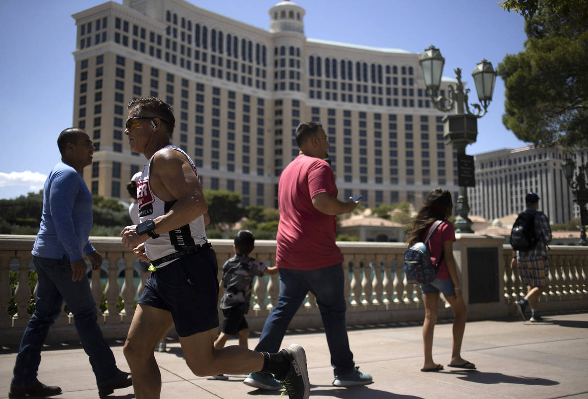 Passersby and runners move past the Bellagio on the third day that the Strip has been reopened ...