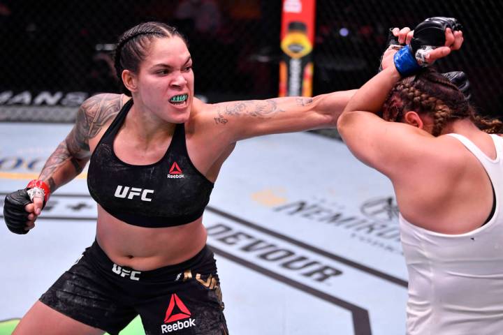 Amanda Nunes, left, of Brazil punches Felicia Spencer of Canada in their featherweight champion ...