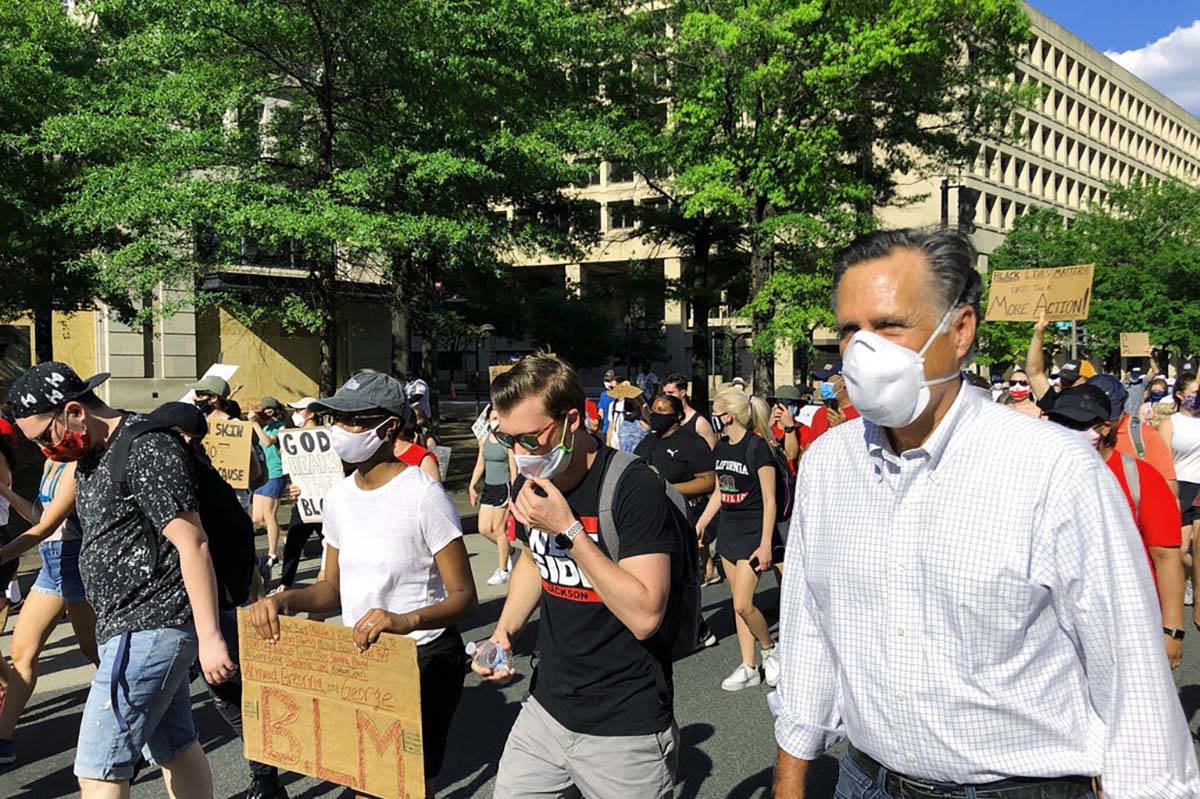 Sen. Mitt Romney, R-Utah, marches with a crowd singing "Little Light of Mine" in Wash ...