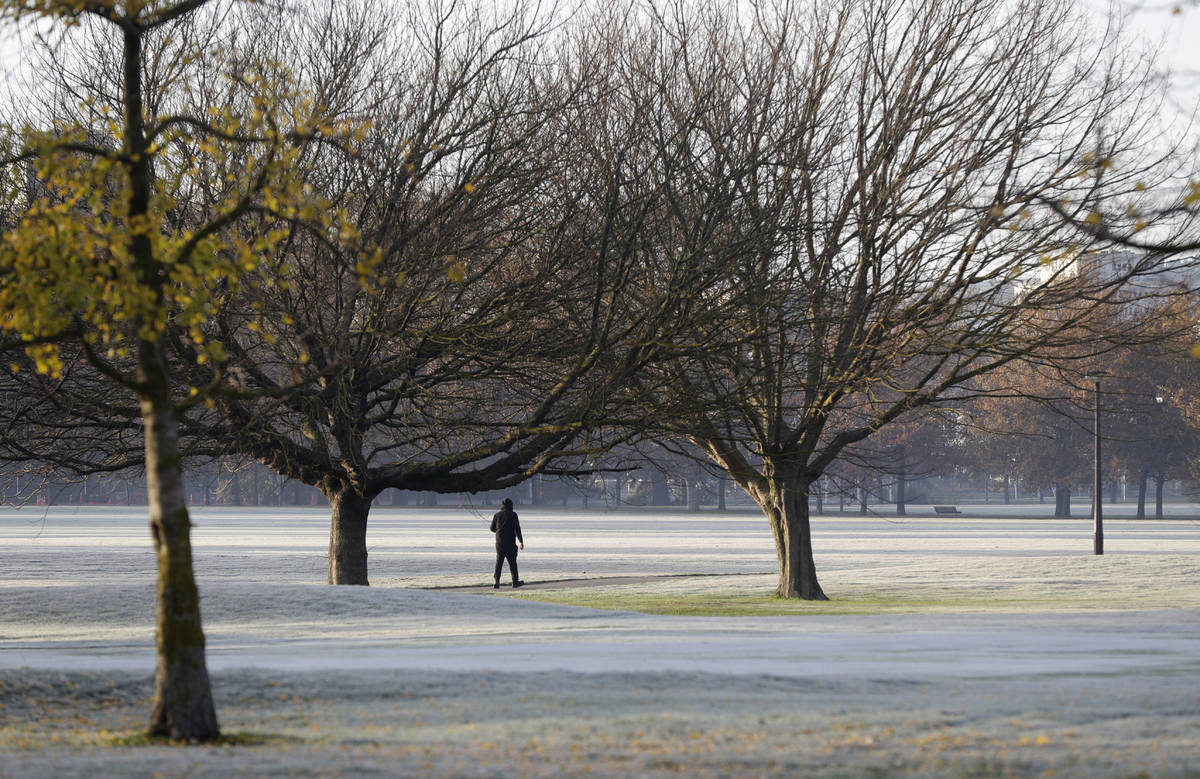 A man walks across the frost covered fairways of a golf course in central Christchurch, New Zea ...