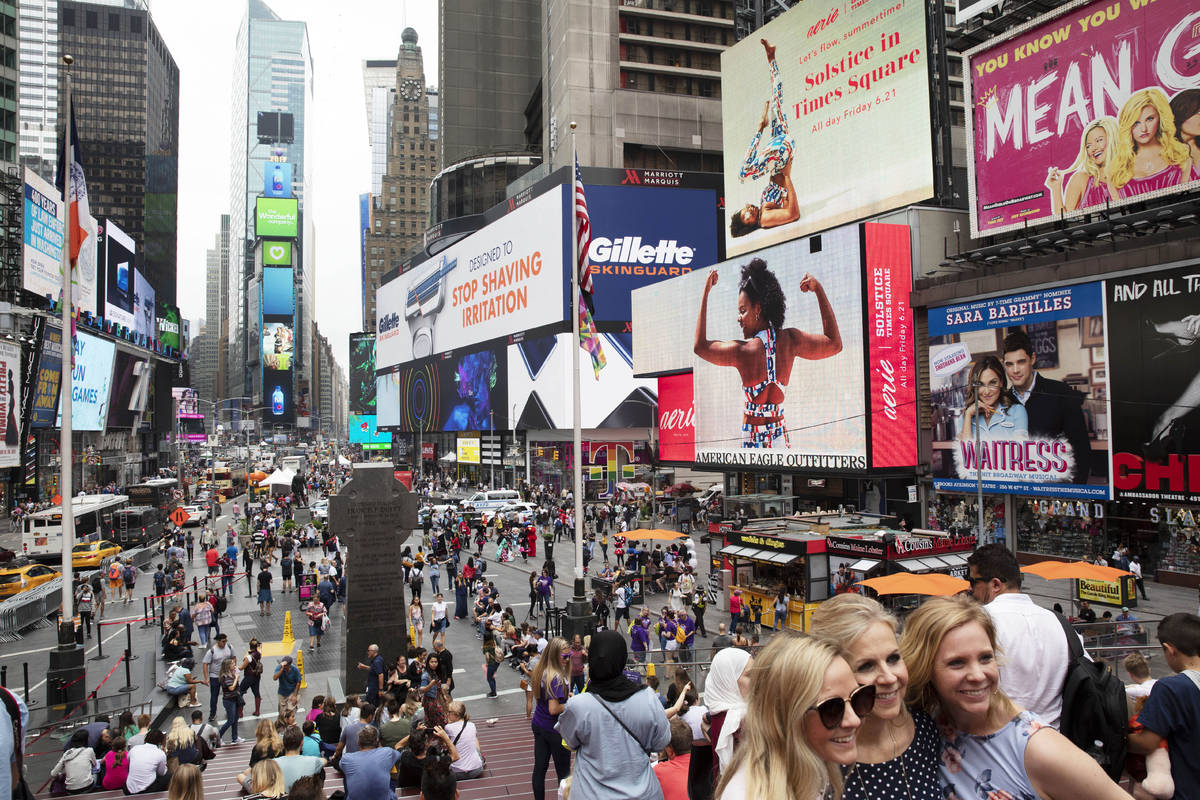 In a June 20, 2019, file photo, tourists visit Times Square in New York. After three months of ...