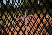 A cross with Trayvon Martin's name is tied to a fence near the White House as demonstrators pro ...