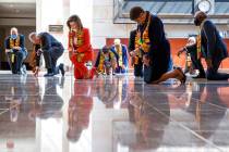 House Speaker Nancy Pelosi of Calif., center, and other members of Congress, kneel and observe ...