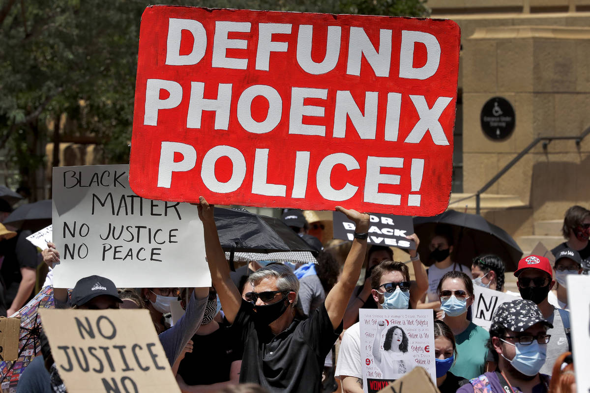 Protesters rally Wednesday, June 3, 2020, in Phoenix, demanding that the Phoenix City Council d ...