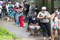 Steven Posey checks his phone as he waits in line to vote, Tuesday, June 9, 2020, at Central Pa ...
