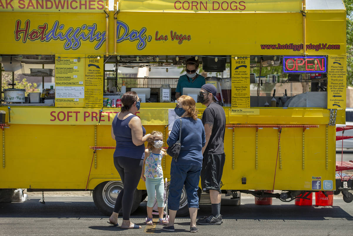 Customers place an order at the Hot Diggity Dog Las Vegas food truck while parked about Desert ...