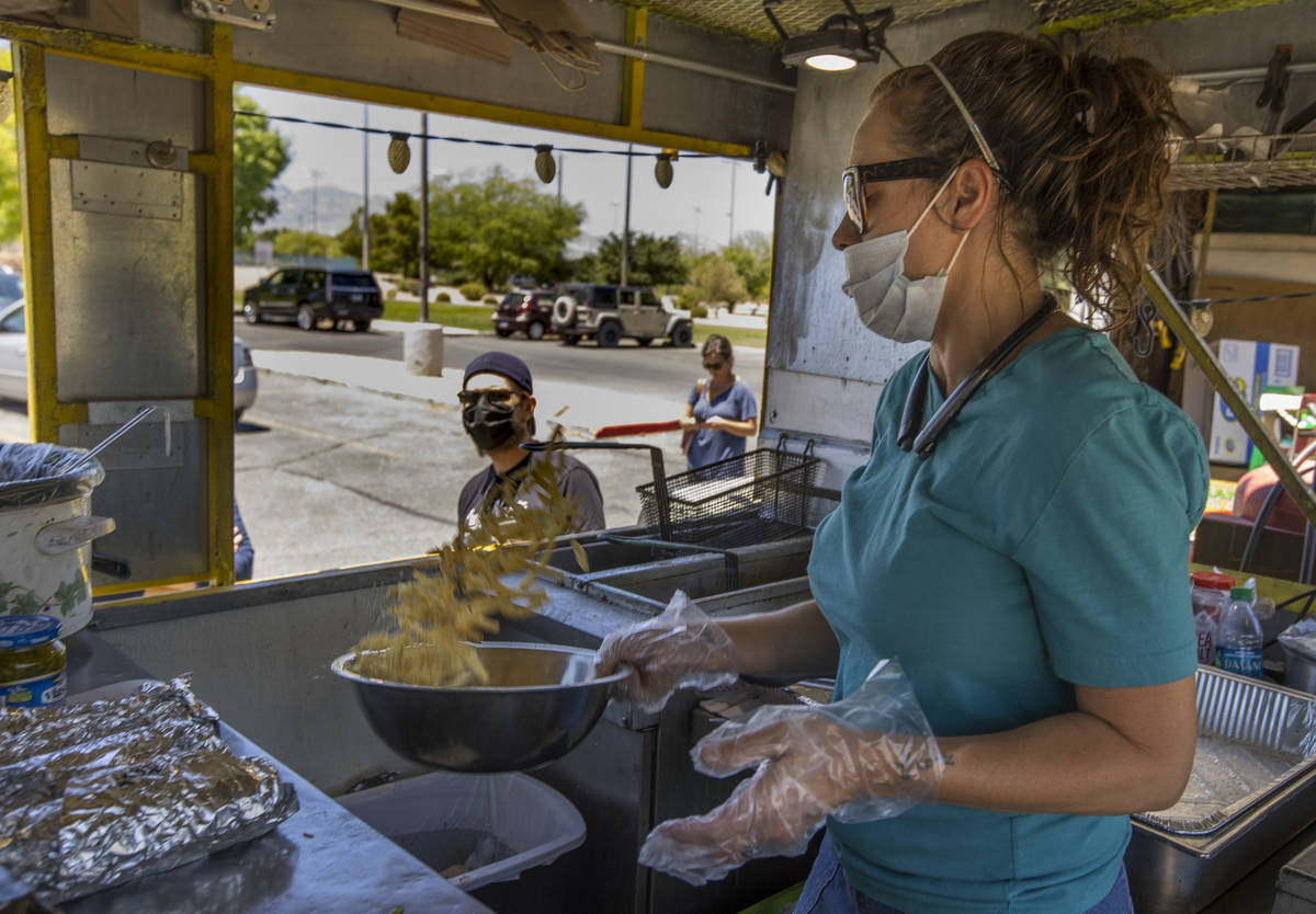 Jenny Noel of the Hot Diggity Dog Las Vegas food truck tosses a bowl of fries with seasonings w ...