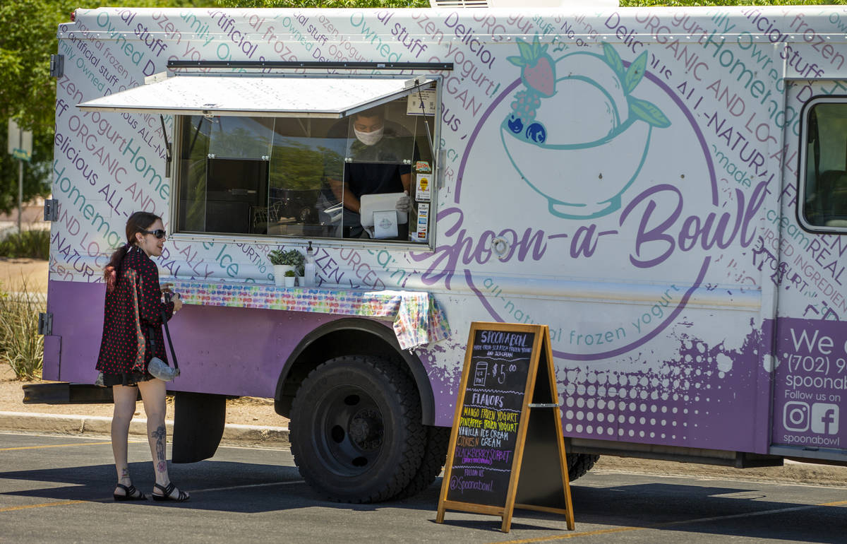 A customer awaits her dessert from the Spoon-a-Bowl food truck parked about the Desert Breeze C ...