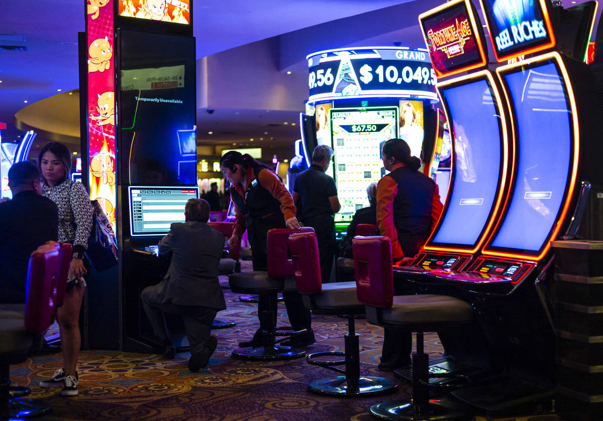 Slot attendants help shut down machines shortly before midnight at the Luxor in Las Vegas on Mo ...