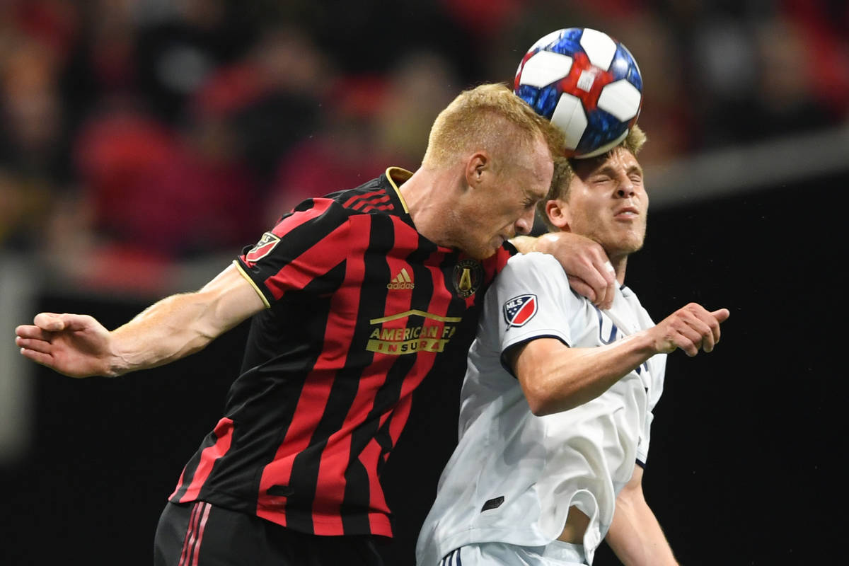 In this Oct. 19, 2019, file photo, Atlanta United defender Jeff Larentowicz, left, and New Engl ...
