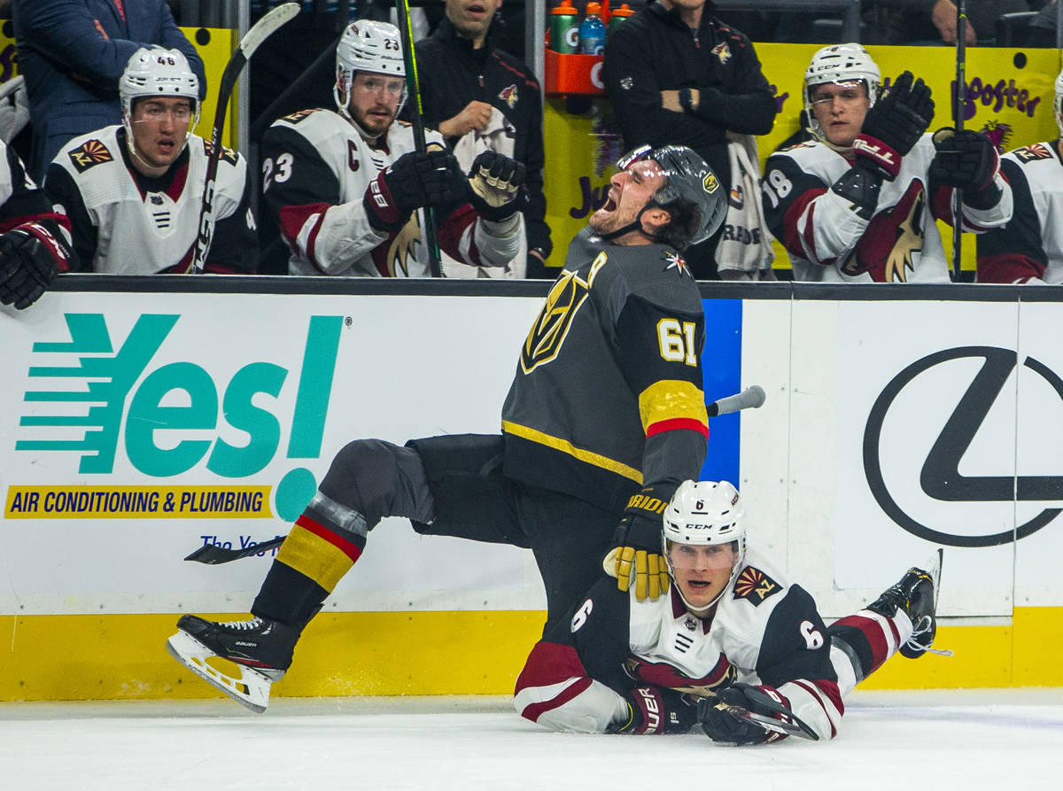 Vegas Golden Knights right wing Mark Stone (61, left) yells out in pain as Arizona Coyotes defe ...