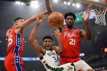 Milwaukee Bucks' Giannis Antetokounmpo is fouled as he drives between Philadelphia 76ers' Ben S ...