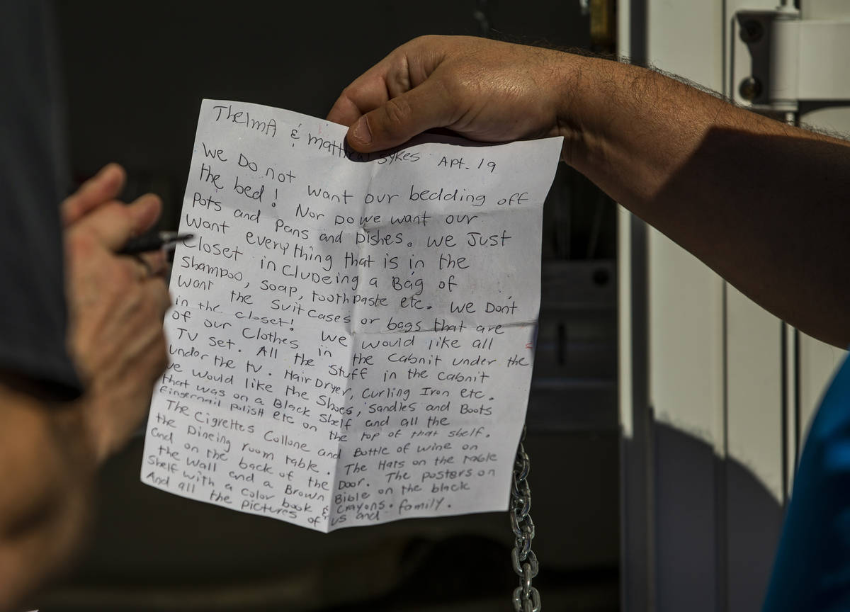 Former resident Matthew Sykes, right, presents a note of the specific possessions he wants to ...